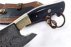 Handmade butcher knife displaying damascus steel blade pattern and hand engraved brass details